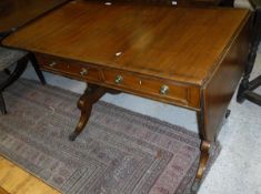 A Regency mahogany and walnut banded sofa table with two drawers to the top on tapering end