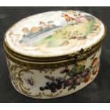 A Continental porcelain dressing table box of oval form decorated with ladies and gallants in