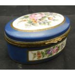 A late 19th Century French porcelain oval dressing table box decorated with panels of flowers on a