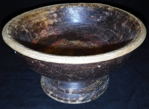 An Indian carved treen ware pedestal bowl with raffia rim