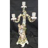 An early 20th Century German figural candelabra of a woman and child by a rose-encrusted pillar