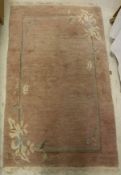 A Tibet rug of plain lilac ground with simple floral decorated corners,