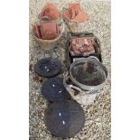 A collection of baskets, terracotta tiles, iron drain covers, iron wares,