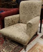 An early Victorian salon chair in all over floral upholstery on mahogany turned legs to brown china