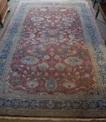 A Ziegler designed carpet, the central panel set with all-over floral design on a red ground,