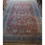 A Ziegler designed carpet, the central panel set with all-over floral design on a red ground,