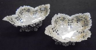 A pair of late Victorian pierced silver bonbon dishes of lobed form raised on pierced feet with