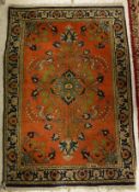 A Persian rug, the central panel set with floral spray on a red ground within a stepped blue,