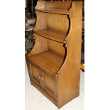 An Ercol elm bookcase cabinet of small proportions,