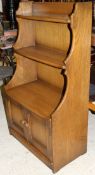 An Ercol elm bookcase cabinet of small proportions,