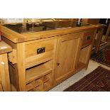 A light oak side unit buffet with black marble top above two drawers and central cupboard door