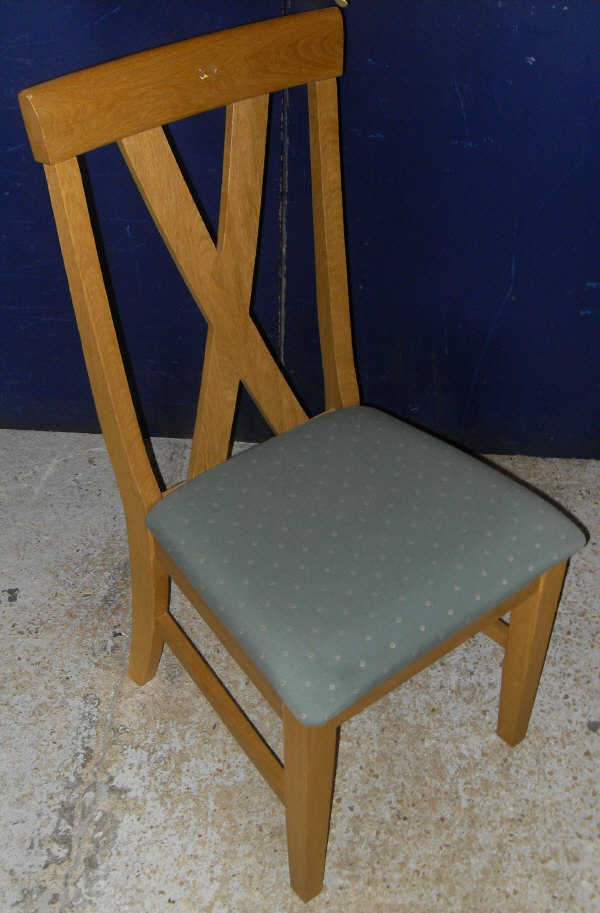 A modern light oak extending dining table, the plain top above square tapering legs,