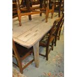 A pine plank top rectangular kitchen table with cleated end supports on square section legs,