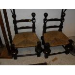 A pair of oak framed low chairs in the Spanish style,