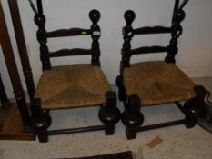 A pair of oak framed low chairs in the Spanish style,