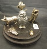 A car mascot in the form of an owl housed on a hard wood stand base,