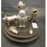 A car mascot in the form of an owl housed on a hard wood stand base,