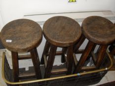 A set of three elm seated circular bar stools on square section tapering supports