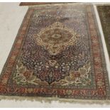 An Oriental carpet, the central panel set with a floral decorated medallion on a blue ground,