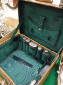 An early 20th Century leather ladies travelling vanity case containing various cut glass and silver