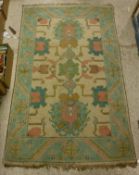 A Caucasian carpet, the central panel set with geometric designs on a cream ground,