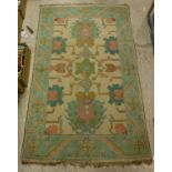 A Caucasian carpet, the central panel set with geometric designs on a cream ground,