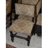 A set of four early 20th Century oak framed dining chairs with cream ground florally decorated