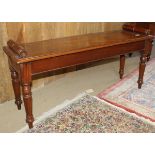 A mahogany window seat in the Victorian manner with scroll handles and single piece top with