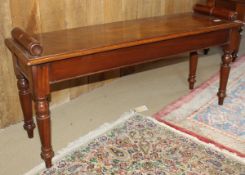 A mahogany window seat in the Victorian manner with scroll handles and single piece top with