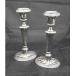 A pair of late Victorian silver sheathed candlesticks in the Adam manner with fluted/fan decoration,