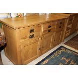 A light oak sideboard with three drawers above three cupboard doors