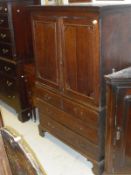 An 18th Century oak cabinet on chest with two cupboard doors above two dummy drawers and two long
