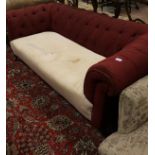 A Victorian Chesterfield button back sofa in red upholstery on turned and ringed front legs to