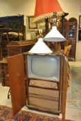 A Defiant CRT TV housed in a walnut case together with three various mahogany standard lamps
