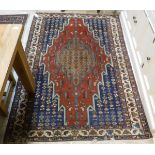 A Caucasian rug, the central panel set with floral decorated graduated medallions on a blue,