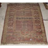 A Turkish prayer rug, the central panel set with geometric design on a red ground,