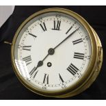 A brass cased ship's style wall clock with Arabic and Roman numerals,