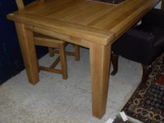 A light oak extending rectangular dining table on square section legs,