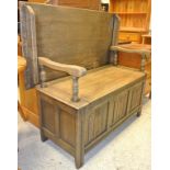 A 20th Century oak Monks bench with linen fold decoration to the front panels