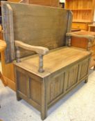 A 20th Century oak Monks bench with linen fold decoration to the front panels