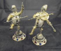 A pair of Continental white metal mounted and jewel set figures of rustic musicians