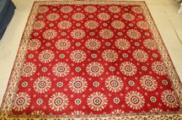 A red ground Axminster carpet with all over floral motifs in red and creams within a stepped cream