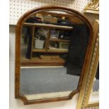 A shaped walnut framed wall mirror