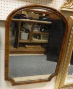 A shaped walnut framed wall mirror