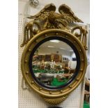 A 19th Century gilt framed convex circular wall mirror, the top surmounted by an eagle,