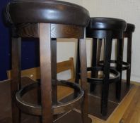 Three modern circular bar stools with brown leatherette seats