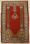 A Persian prayer rug, the central panel set with an urn of flowers, within a columned archway,
