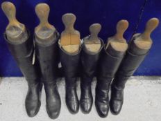 A pair of black and tan Hunting boots with wooden trees,