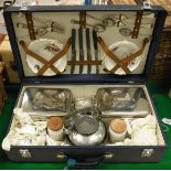 A mid 20th Century vintage fitted picnic hamper containing sandwich tins, tea plates, teacups,