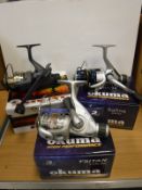 A collection of seven boxed and un-used fixed spool reels, comprising five Okuma TTR-30 reels,
